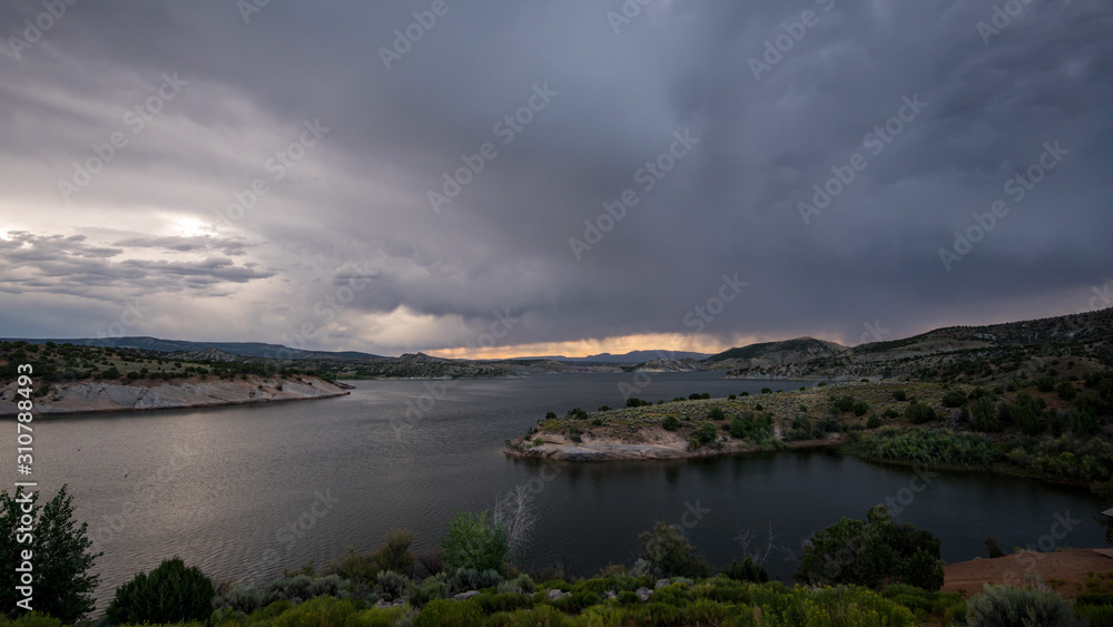 Storm blowing over lake with dark clouds through the sky.