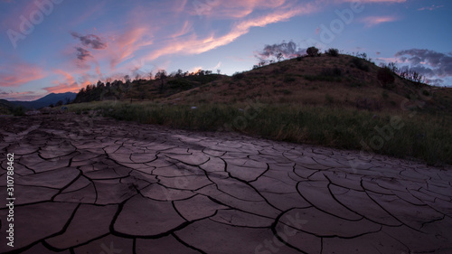 Dry cracked mud with pink clouds in Diamond Fork Canyon in Utah.