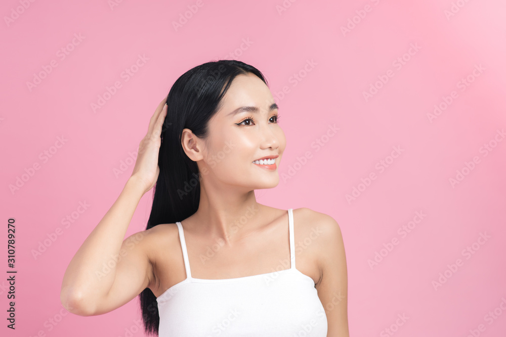 Young beautiful Asian woman taking care of her hair. Beauty portrait , natural make-up, beauty face, isolated over pink background. Young beautiful Asian woman taking care of her hair. Beauty portrait , natural make-up, beauty face, isolated over pink background.
