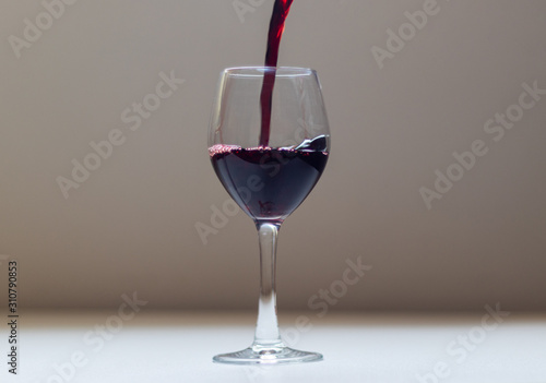 wine being poured into the glass bowl with the movement of the wine as it touches the edges of the glass.