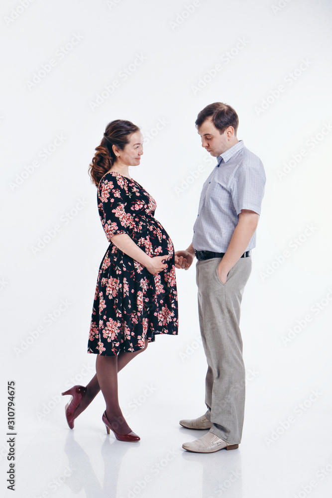 loving couple embracing on a white background. A man and a woman look into each other's eyes. Husband hugs pregnant wife. Valentine's day. February 14 loving couple embracing on a white background. A man and a woman look into each other's eyes. Husband hugs pregnant wife. Valentine's day. February 14