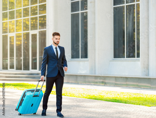 Young man with luggage for business trip outdoors