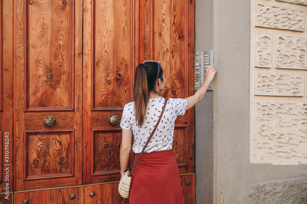 The girl calls the intercom for access inside the house. The girl calls the intercom for access inside the house.