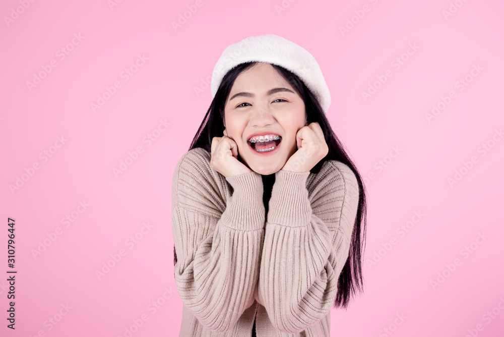 Happy Asian woman wearing brown sweater on pink background. Happy Asian woman wearing brown sweater on pink background.