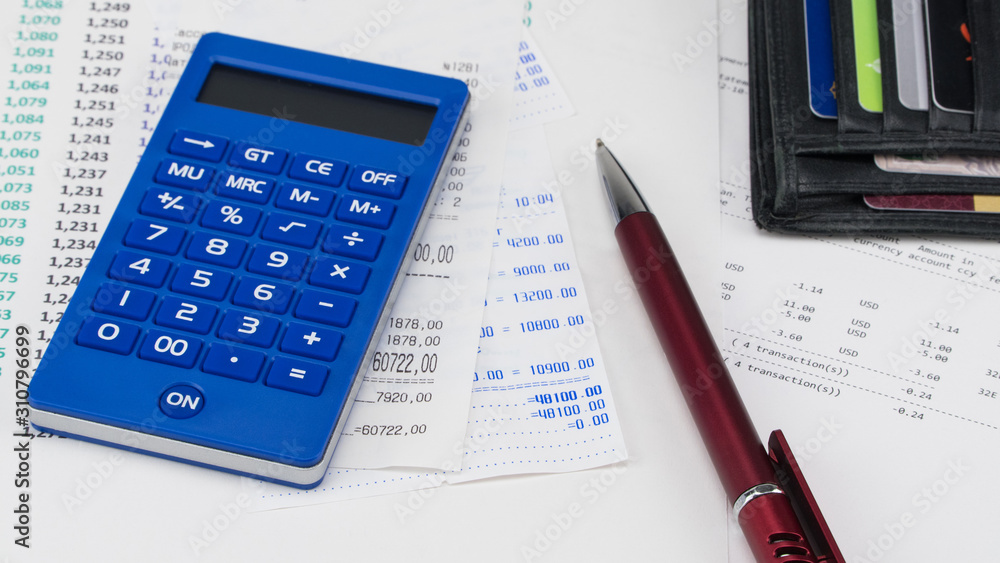 Wallet with payment cards and calculator on top of supermarket receipt. Shopping and payment concept Wallet with payment cards and calculator on top of supermarket receipt. Shopping and payment concept