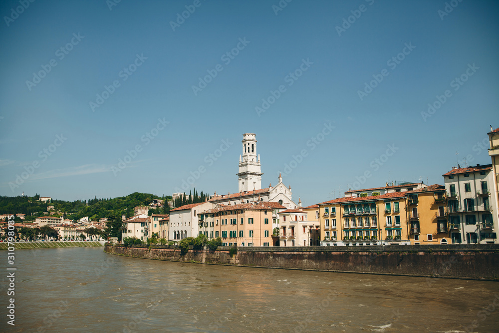 View of traditional old houses and a cathedral or church and river in Verona in Italy.