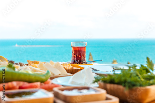 Fototapeta Naklejka Na Ścianę i Meble -  Breakfast on the beach at hotel or resort by the sea in summer season. Holiday and vacation breakfast image.Traditional Turkish or Greek breakfast at bodrum town beach in Turkey or Greece