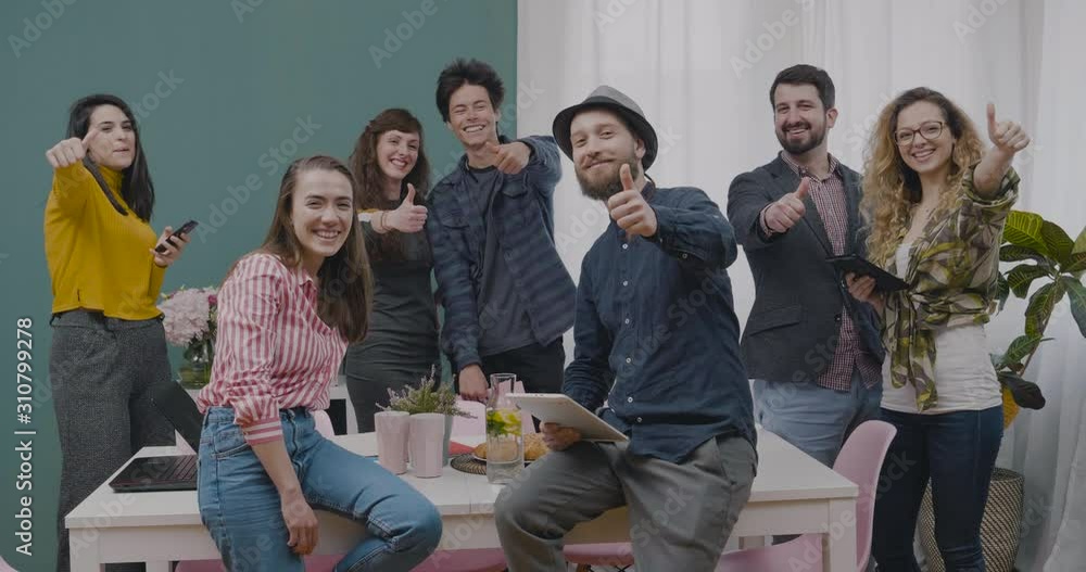 Creative hipsters team business office meeting smiling and showing thumbs up Creative hipsters team business office meeting smiling and showing thumbs up
