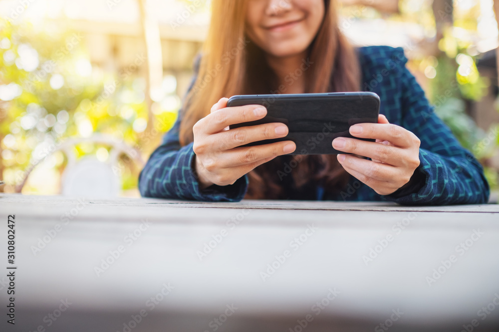 Closeup image of a woman holding , using and playing games in mobile phone Closeup image of a woman holding , using and playing games in mobile phone