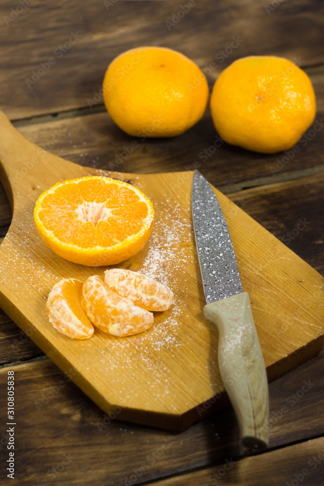orange on a cutting board and a wooden background with a knife orange on a cutting board and a wooden background with a knife