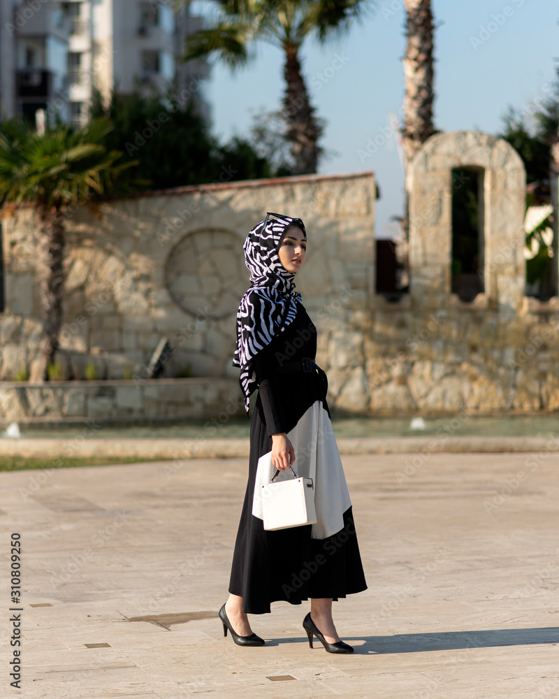 young muslim woman is walking in a modern city