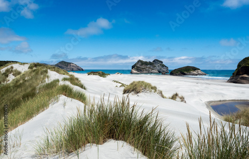 The powder white snad beaches of wharariki near nelson on new zealands south island. photo