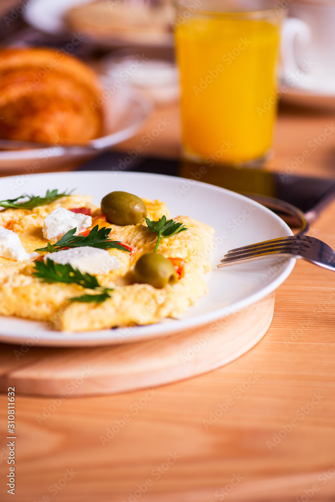 Fluffy omelette with herbs olives and feta cheese, juice on a wooden board. Fluffy omelette with herbs olives and feta cheese, juice on a wooden board.