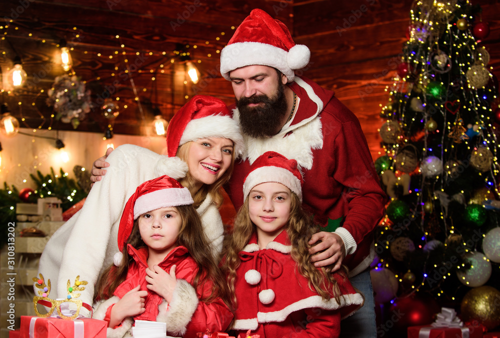Enjoying New Year party. small children and parents in santa hat. merry christmas. Father and mother love kids. Portrait loving family. lot of xmas present boxes. Happy family celebrate new year Enjoying New Year party. small children and parents in santa hat. merry christmas. Father and mother love kids. Portrait loving family. lot of xmas present boxes. Happy family celebrate new year