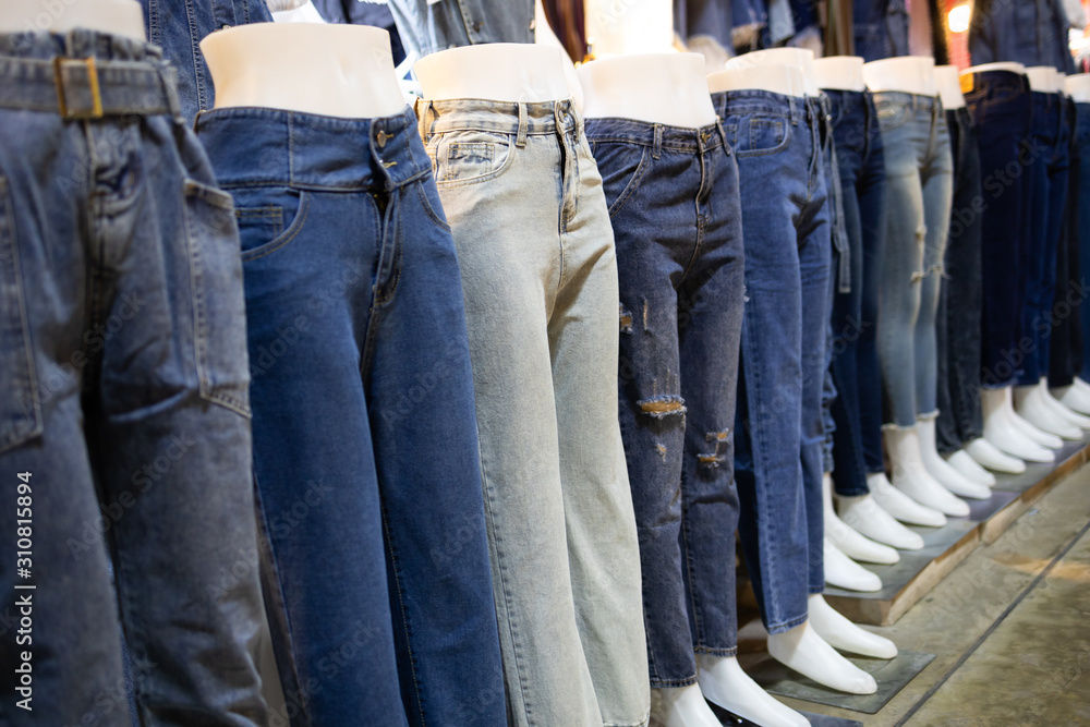 Collection of various types of blue jeans trousers, row of female mannequin  in legs of women's jeans of different colors,advertising pants shop,many  jeans fashion for girl that are comfortable to wear Photos