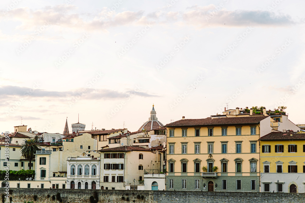 Historic beautiful houses with interesting architecture on the embankment of Florence.