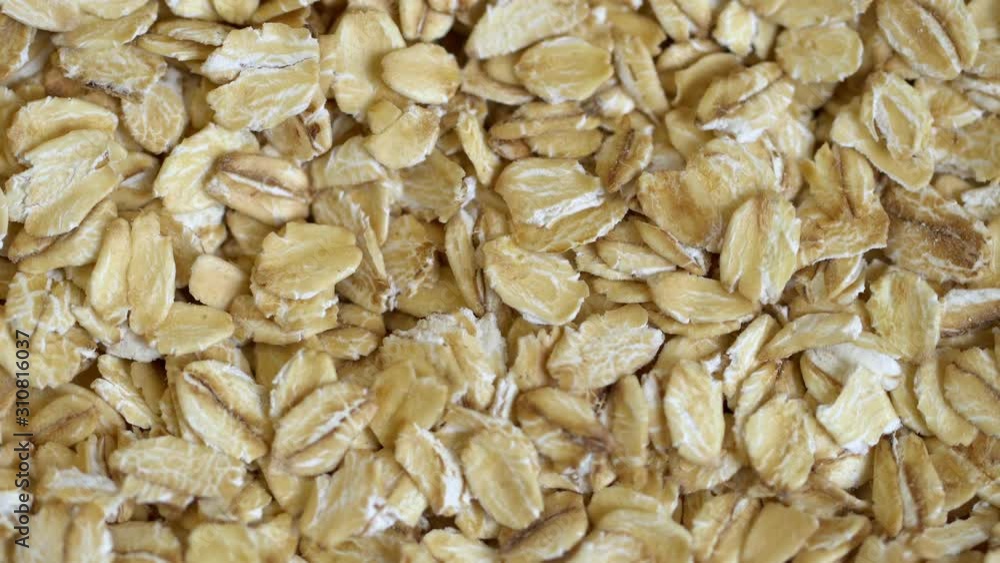 Dry oat flakes grains background, close up rotation loopable 4k top view. Food background. Gastronomy concept, organic food. Macro rotation oat flakes Dry oat flakes grains background, close up rotation loopable 4k top view. Food background. Gastronomy concept, organic food. Macro rotation oat flakes