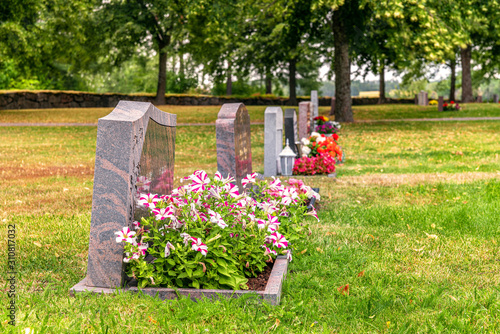 Row of gravestones with colorful flowers