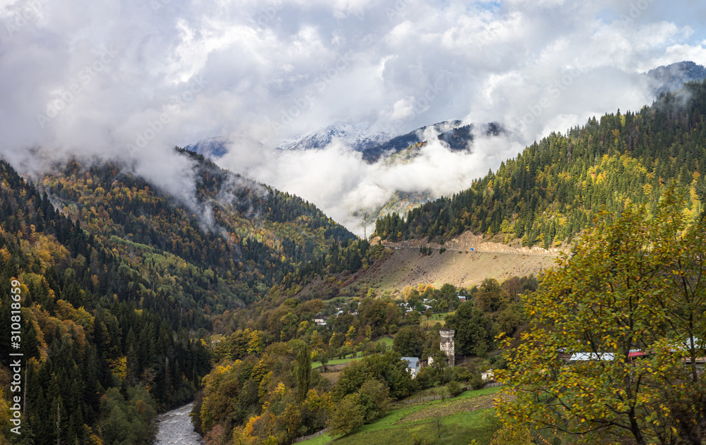 The small village and mountain slopes covered with forests and low thunderclouds in Svaneti in the mountainous part of Georgia The small village and mountain slopes covered with forests and low thunderclouds in Svaneti in the mountainous part of Georgia