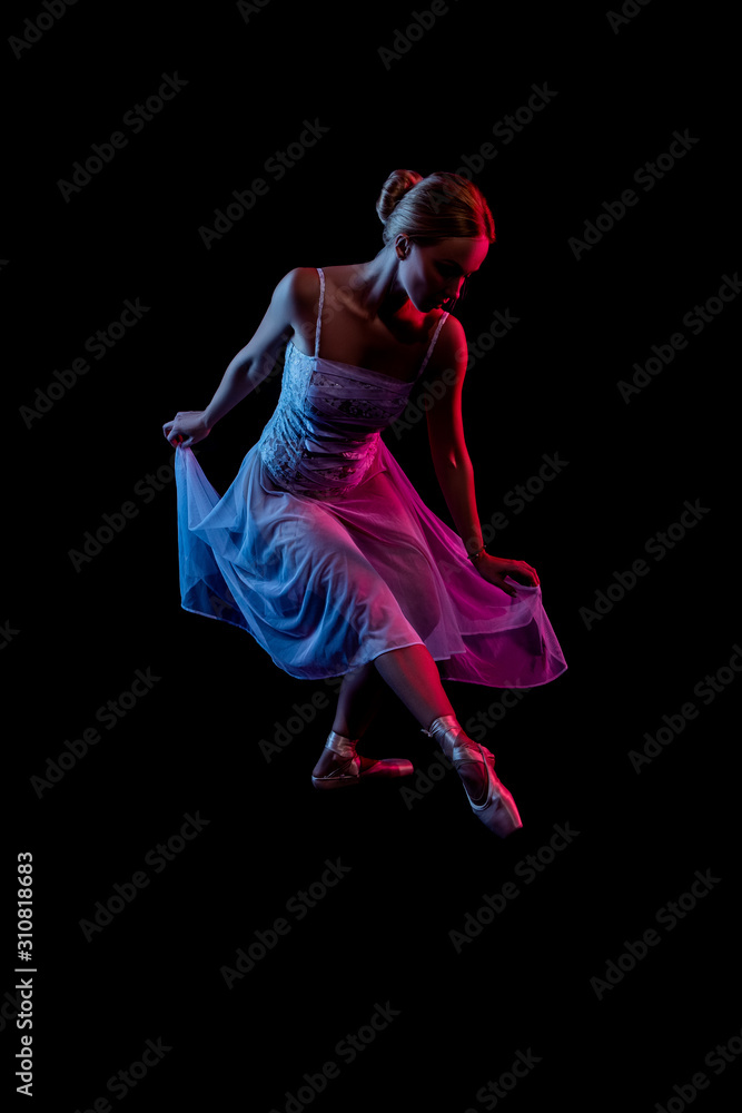 girl in a dress. color portrait ballerina dancing. dancer in motion with the effects of highlighting with color filters in the fog on a black background. Abstract photo in color light   