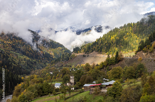 The small village and mountain slopes covered with forests and low thunderclouds in Svaneti in the mountainous part of Georgia