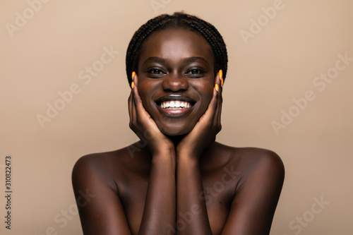Young african girl with perfect skin on beige background. Beauty Skin care concept