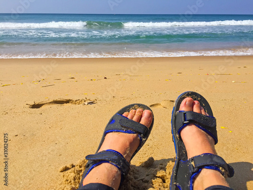 Legs in sandales on the seaside photo