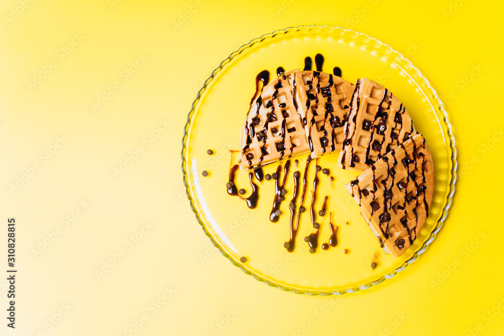 Waffles with chocolate on a yellow background. Waffles with chocolate on a yellow background.