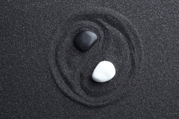 Plexiglas schilderij Zen Yin yang van stenen op zwart zand  © New Africa