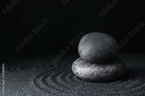 Photography Spa stones on black sand with beautiful pattern, space for text
