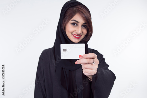Arab Female holding a credit card, focus on the debit card, over white background