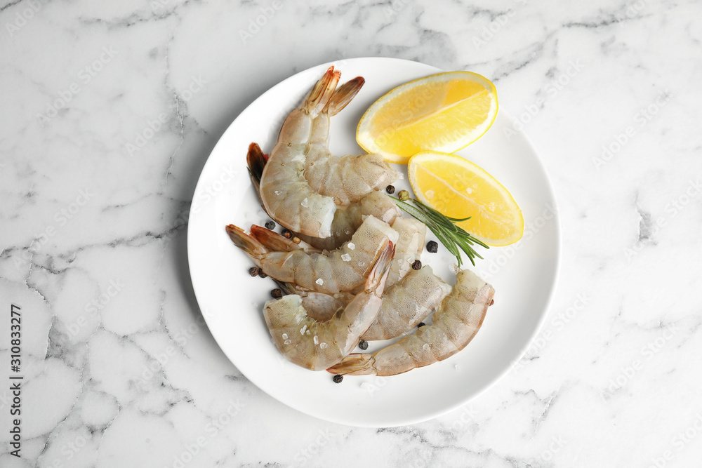 Fresh raw shrimps with lemon and rosemary on marble table, top view Fresh raw shrimps with lemon and rosemary on marble table, top view
