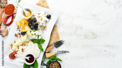 Assorted cheese with grapes and honey. Restaurant dishes. Top view. Free space for your text.