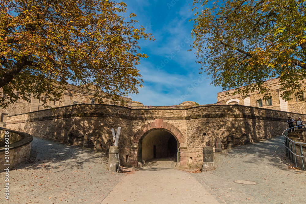 Flanked by two big tress, the tunnel inside the Ehrenbreitstein Fortress leads to the ravelin and countergard of the famous fortification in Koblenz, Germany. 