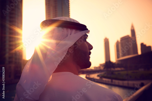 Arab man with kandura enjoying sunrise in Dubai proud of his country,