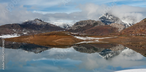 Porma reservoir, Susaron peak snowy and its reflection in the water. Lion. Spain photo