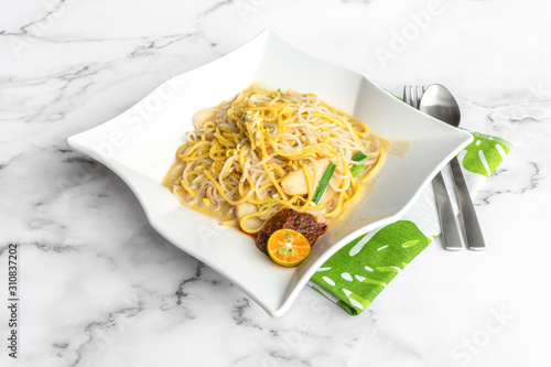 Hokkien Prawn Noodle, is one of the best hawker foods in Singapore. This stir-fried noodle dish is steeped in aromatic stock made of pork bones and prawn heads. Food on table concept.