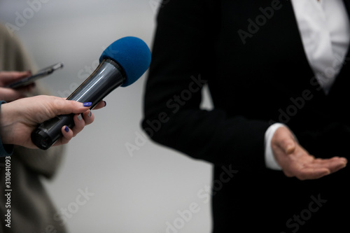 Journalist With Microphone Interviewing Businessman, politician