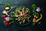 Arugula salad, tuna fillet and figs with blackberry berries. Menu. Free copy space. Top view.