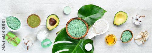 Cosmetics from avocado, avocado oil, sea salt and face cream, on a white wood...