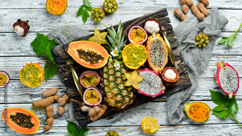 Fototapeta Naklejka Na Ścianę i Meble -  Tropical fruits on a white background: papaya, mangosteen, cactus fruit, pytahaya, pineapple. Top view. Free space for text.