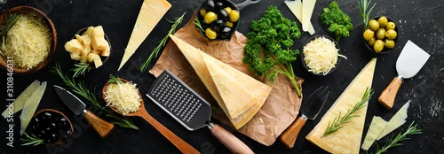 Obraz  z motywem Set of hard cheeses with cheese knives on black stone background. Parmesan. Top view. Free space for your text.