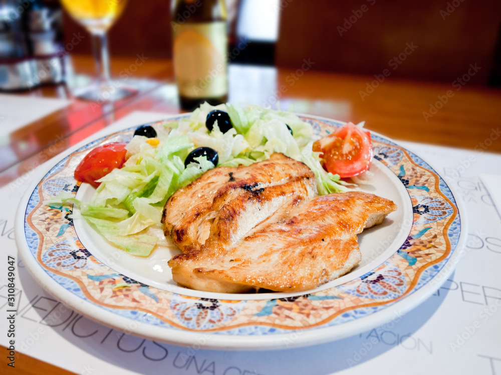 Grilled salmon with spring vegetables on plate, soft focus. Wooden table Grilled salmon with spring vegetables on plate, soft focus. Wooden table