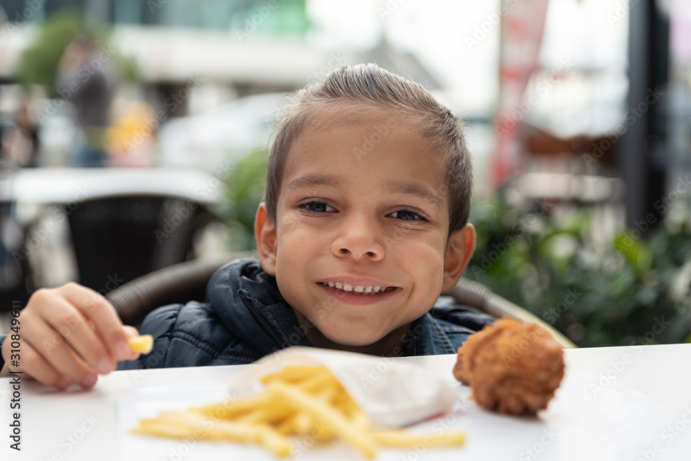 little boy eats french fries and chicken little boy eats french fries and chicken