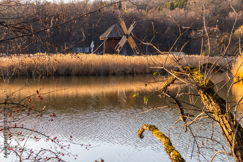 Autumn panorama with windmills on lake