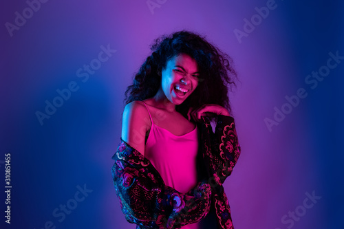 Playful happy party fashion young african girl black mixed race woman wear flower print stylish jacket look at camera enjoy nightclub life isolated on purple studio background, portrait, copy space