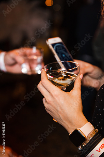 People Chatting at a VIP business corporate event holding their champagne drinks and phones in Eastern Europe Latvia Riga bar cafe restaurant