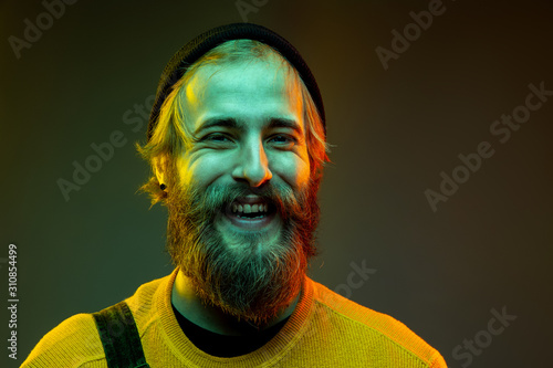 Caucasian woman's portrait isolated on gradient studio background in neon light. Beautiful male model with hipster style. Concept of human emotions, facial expression, sales, ad. Crazy happy laughting