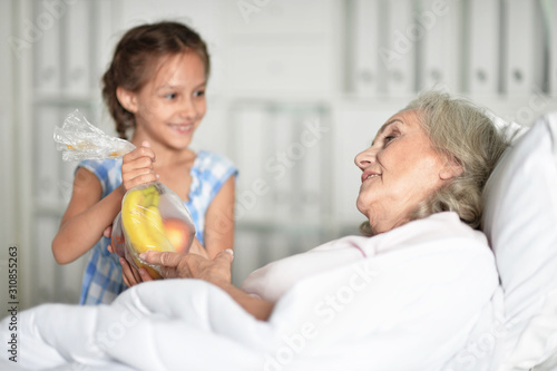 Portrait of granddaughter visiting grandmother in hospital