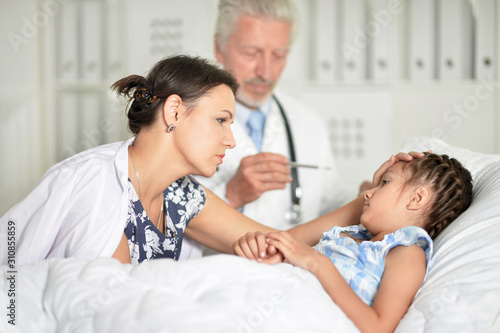 Portrait of sad woman with daughter in hospital ward